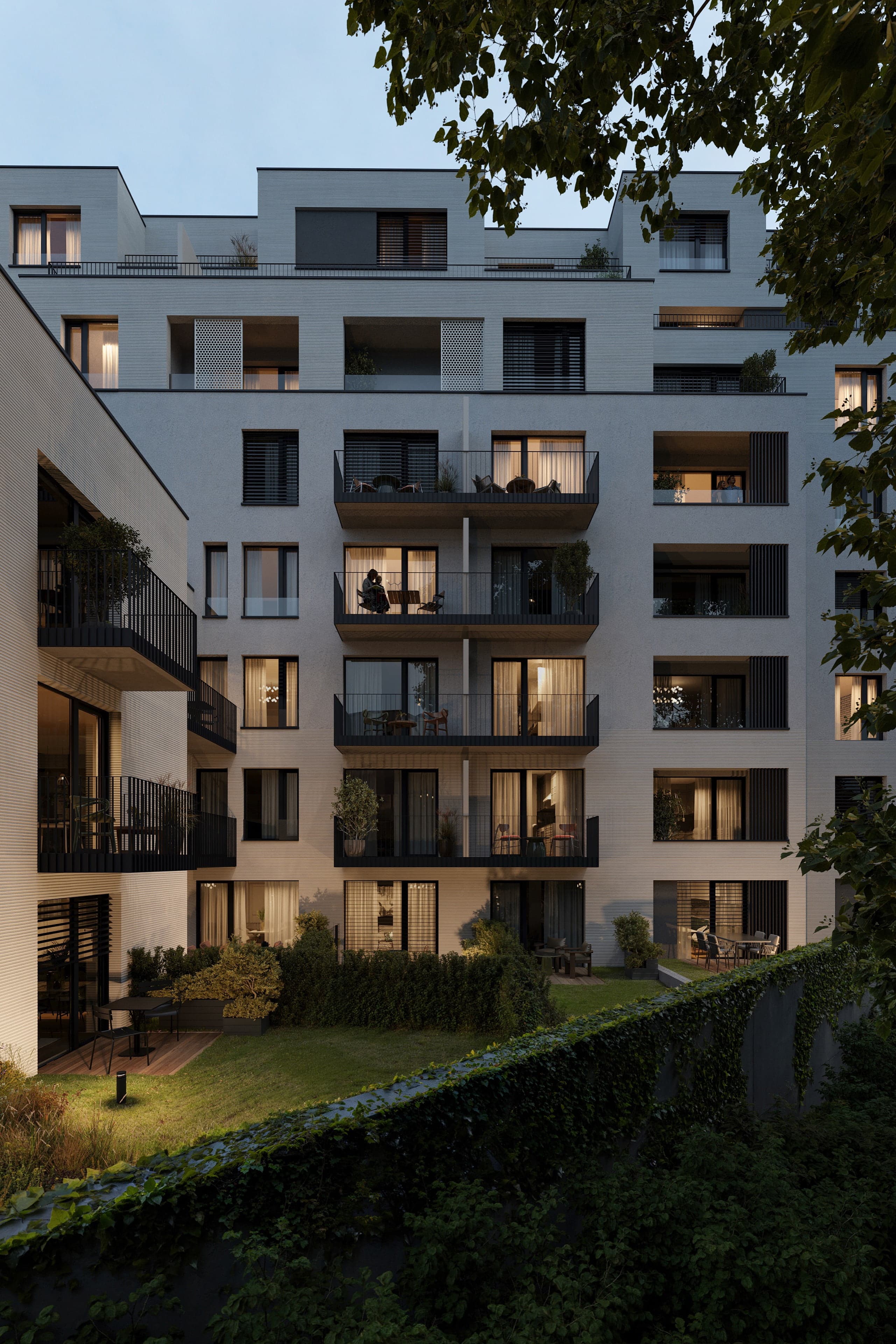 Dvorní fasáda za soumraku – rozsvícené lodžie a balkony nad tichým vnitroblokem