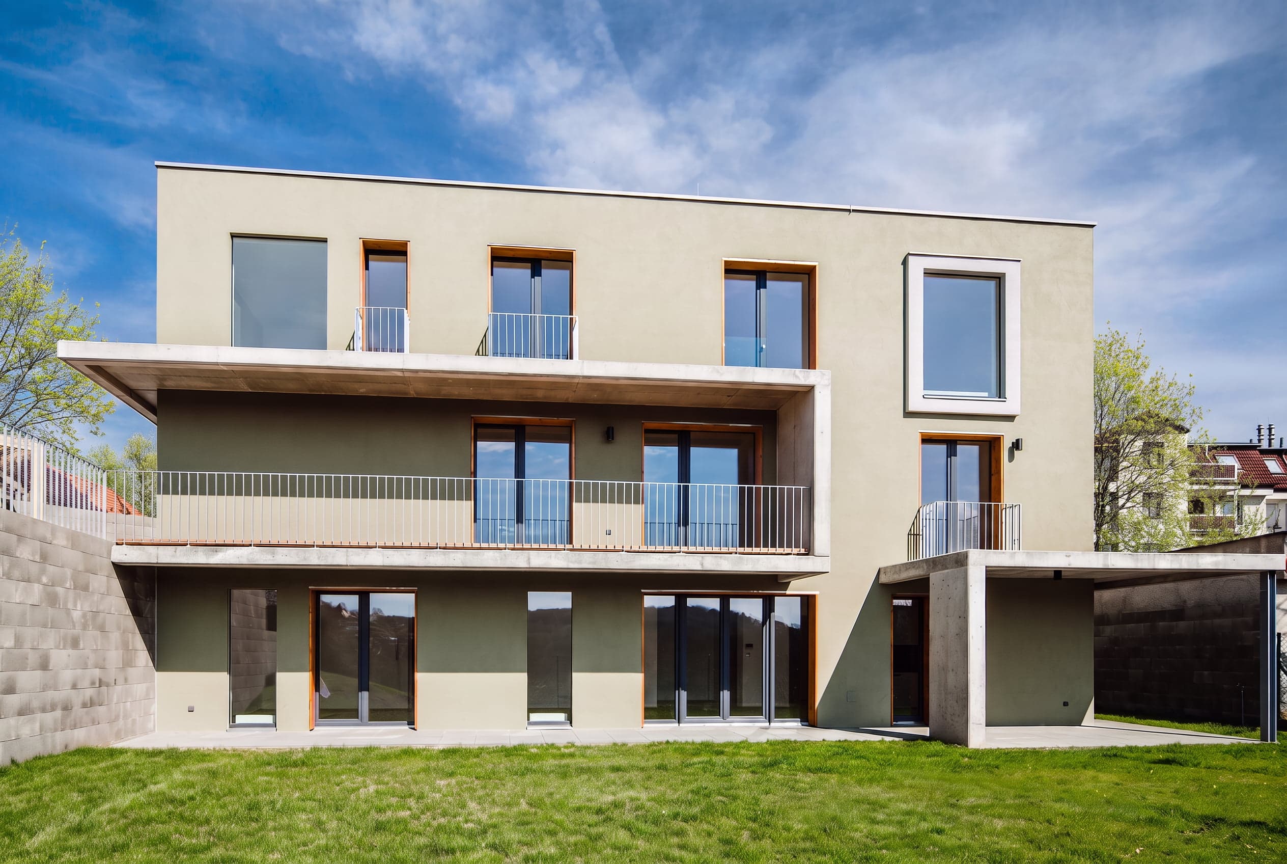Zahradní průčelí přes všechna tři podlaží – tři úrovně teras a lodžií, spodní podlaží v tmavší zelené